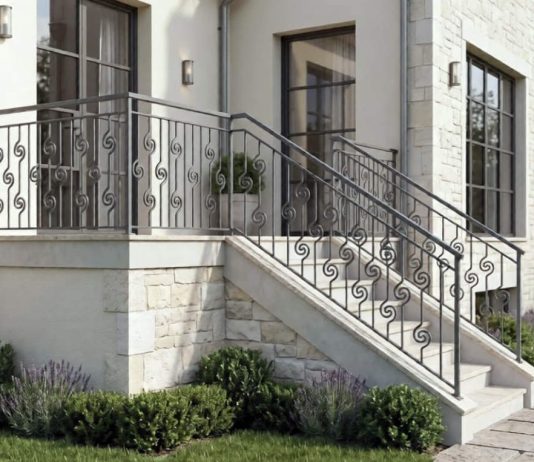 Barandilla de hierro en escalera exterior de vivienda con diseño ornamental